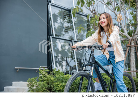Happy Asian beautiful young woman riding bicycle on street outdoor near building city, Portrait of smiling female lifestyle using bike in summer travel means of transportation, ECO friendly Happy Asian beautiful young woman riding bicycle on street outdoor near building city, Portrait of smiling female lifestyle using bike in summer travel means of transportation, ECO friendly 102113987