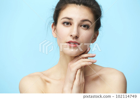 head and shoulder portrait of a young caucasian woman isolated on blue background 102114749