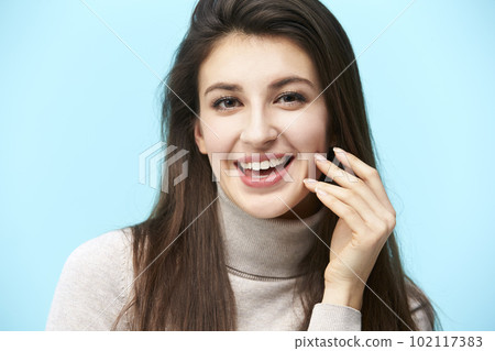 head and shoulder portrait of a young caucasian woman isolated on blue background head and shoulder portrait of a young caucasian woman isolated on blue background 102117383