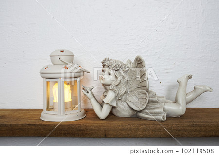 White lantern and Fairy statue Home decoration accessories on wooden shelves White lantern and Fairy statue Home decoration accessories on wooden shelves 102119508