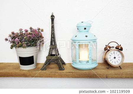 Eiffel tower statue, artificial plant, vintage alarm clock and blue lantern with LED candle light on wooden shelves 102119509