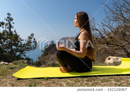 Beautiful woman practicing yoga in the park,Yoga Ardha Padmasana Half lotus pose. 102126067