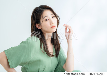 在陽光透過樹葉的白色背景下做護膚的年輕女性 102126200