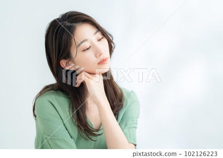 在陽光透過樹葉的白色背景下做護膚的年輕女性 102126223