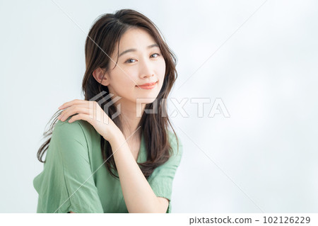 在陽光透過樹葉的白色背景下做護膚的年輕女性 102126229