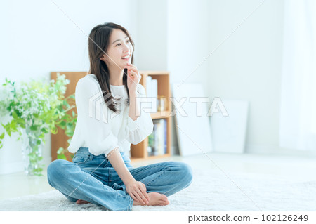 Young woman doing skin care in the living room Young woman doing skin care in the living room 102126249