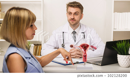Young woman on a consultation with a male surgeon or therapist in his office. 102128200
