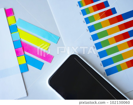 Graphs, documents and smartphones on the table 102130060
