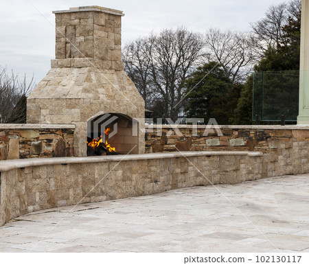 Stone patio with burning fireplace and copy space Stone patio with burning fireplace and copy space 102130117