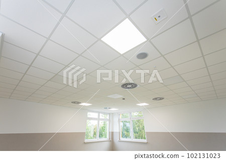 Bottom view of the panel ceiling on the diagonal of the room with a visible perspective. Bottom view of the panel ceiling on the diagonal of the room with a visible perspective. 102131023