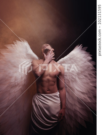 Young strong angel with white wings from heaven. Angel with muscular body. Sensual man Young strong angel with white wings from heaven. Angel with muscular body. Sensual man 102131595
