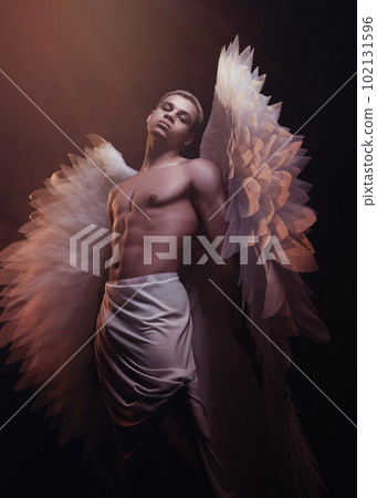 Young strong angel with white wings from heaven. Angel with muscular body. Sensual man 102131596