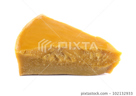 A piece of natural beeswax on a white background. A piece of natural beeswax on a white background. 102132933