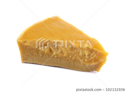 A piece of natural beeswax on a white background. A piece of natural beeswax on a white background. 102132936