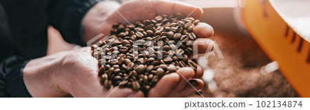 Business owner checks the quality of roasting coffee beans on small factory. Close-up 102134874