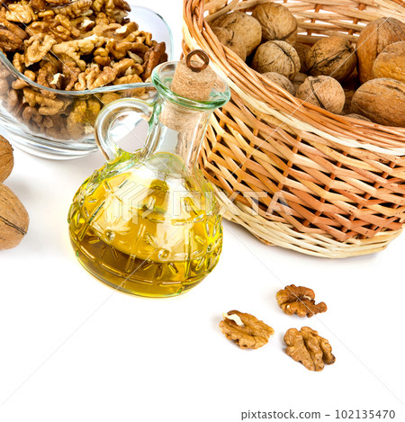 Walnuts and nut oil in a bottle isolated on white . Walnuts and nut oil in a bottle isolated on white . 102135470