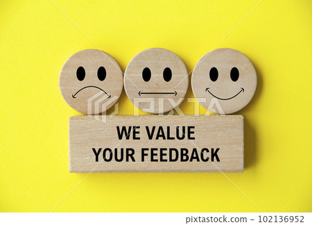 We value your feedback text on wooden block with happy, sad and neutral emoticon faces on wooden circle. Customer feedback, satisfaction and evaluation and concept 102136952
