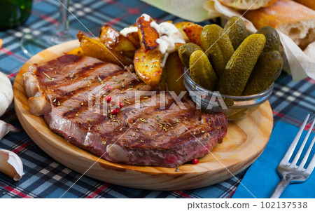 Beef entrecote with spices on a wooden round board 102137538