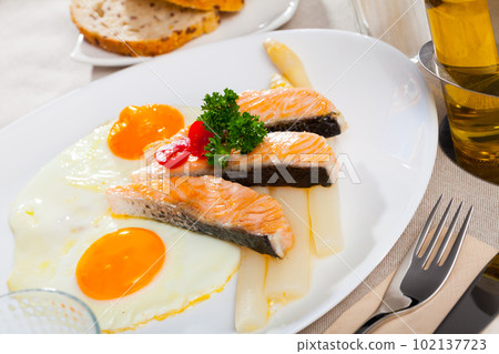 Delicious grilled salmon with eggs, tomatoes, asparagus and parsley Delicious grilled salmon with eggs, tomatoes, asparagus and parsley 102137723