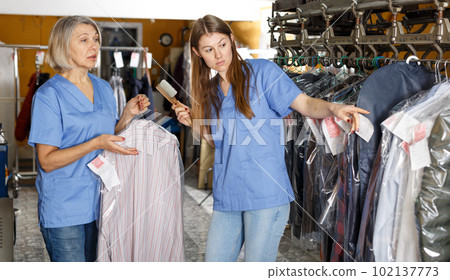 Workers inspecting clothes after cleaning 102137773