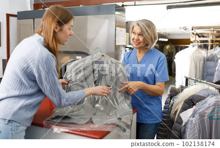 Fine worker giving woman her clean clothes 102138174