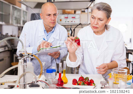 Biochemists recording experimental procedure and results Biochemists recording experimental procedure and results 102138241