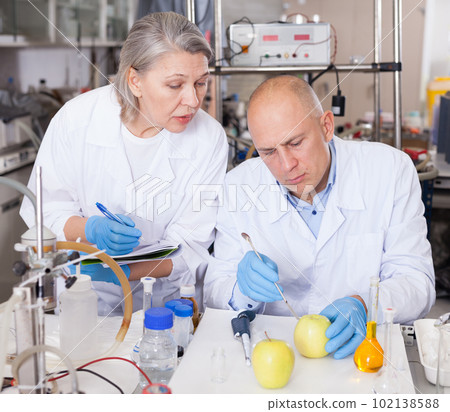 Scientists taking notes while checking agricultural products 102138588