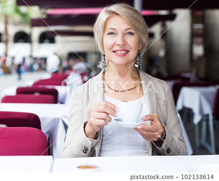 Mature woman 50s years old is lunching with coffee 102138614