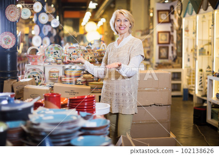Positive mature woman standing at ceramic section Positive mature woman standing at ceramic section 102138626