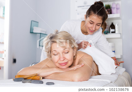Mature woman having massage Mature woman having massage 102138676
