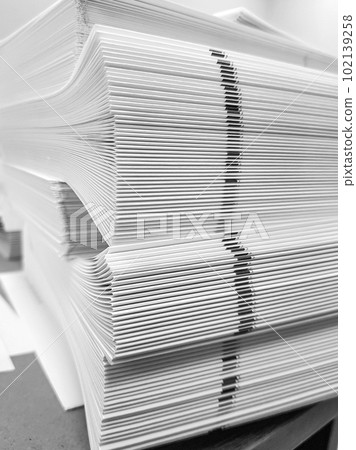 A stack of blank paper, book blocks prepared for binding in a printing house 102139258