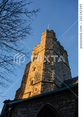 A historic stone block church bathed in the setting sun on the outskirts of London A historic stone block church bathed in the setting sun on the outskirts of London 102142395