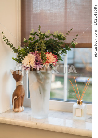 Vase with flowers near the window 102143095