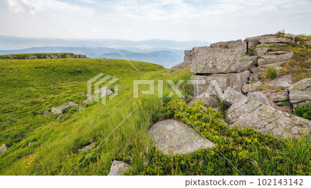 boulders on the grassy hillside. mountainous summer landscape. clouds on the blue sky boulders on the grassy hillside. mountainous summer landscape. clouds on the blue sky 102143142