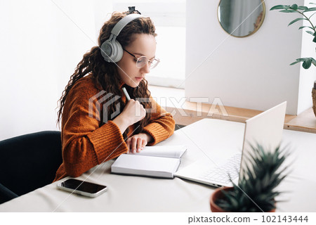 Young woman elearning from home, attending virtual class and remote conference meetings on laptop Young woman elearning from home, attending virtual class and remote conference meetings on laptop 102143444