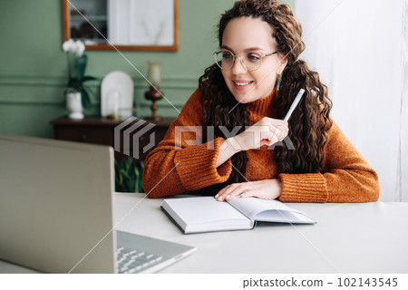 Young Woman Learning and Working Remotely from Home Office with Laptop Computer. Beautiful Young 102143545