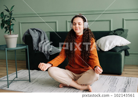 Mindful woman finding inner peace through yoga and meditation with calming music and podcasts 102143561