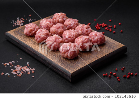 Raw meatballs of minced meat beef, pork or chicken with salt, spices and herbs 102143610