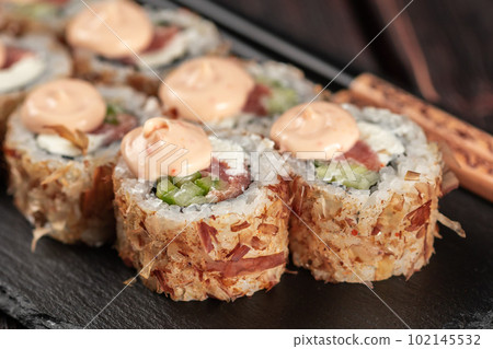 Close up Salmon sushi roll with tuna flakes and souse close-up - sushi asian menu and Japanese food 102145532