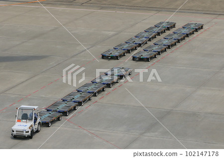 Working cars at the airport Container dollies lined up 102147178