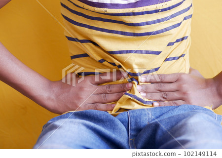 boy suffering stomach pain sitting on chair  102149114