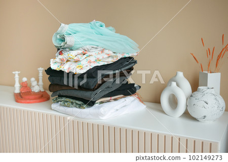 Stack of clothes on table indoor. 102149273