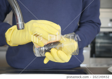 hand in gloves washing a glass  102149432