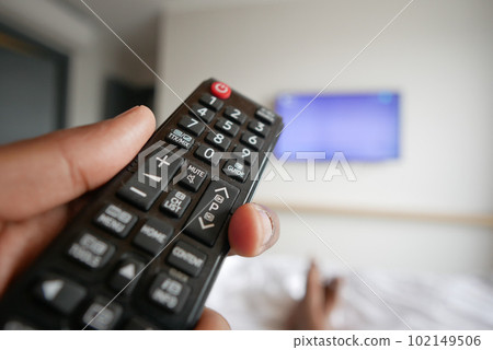close up of man hand holding tv remote. 102149506