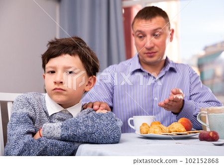 Upset father and offended son arguing in domestic interior 102152868