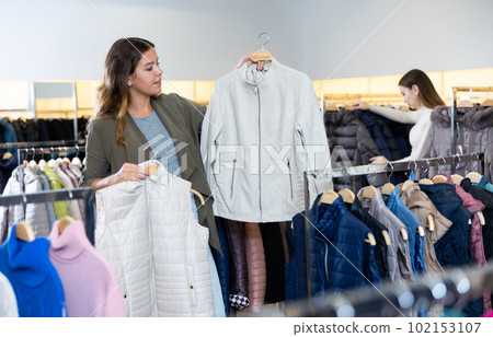 Young woman looking for jacket in store Young woman looking for jacket in store 102153107