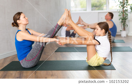 Happy mother and daughter practicing yoga poses Happy mother and daughter practicing yoga poses 102153202