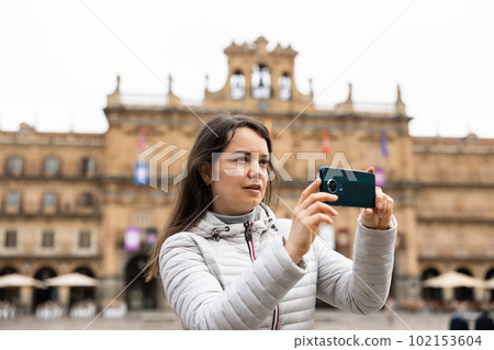 Woman is taking photos on her camera while journey through the Plaza Mayor. Spain Woman is taking photos on her camera while journey through the Plaza Mayor. Spain 102153604