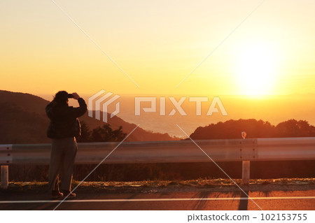 A silhouette of a woman traveling along the coast of Nishi-Izu on the Izu Peninsula looking at the sunset A silhouette of a woman traveling along the coast of Nishi-Izu on the Izu Peninsula looking at the sunset 102153755