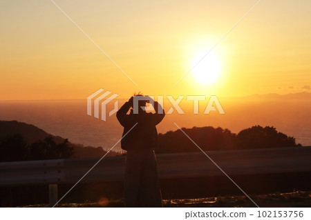 A silhouette of a woman traveling along the coast of Nishi-Izu on the Izu Peninsula looking at the sunset A silhouette of a woman traveling along the coast of Nishi-Izu on the Izu Peninsula looking at the sunset 102153756